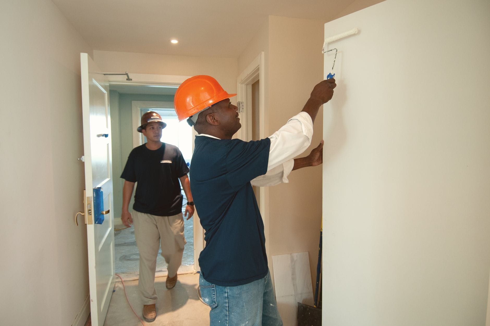 Painter rolling paint onto an interior wall during a home repaint